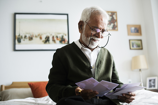 Senior man wearing glasses looks at family photos
