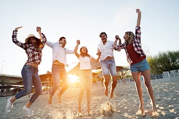 Young friends jumping on the beach after LASIK